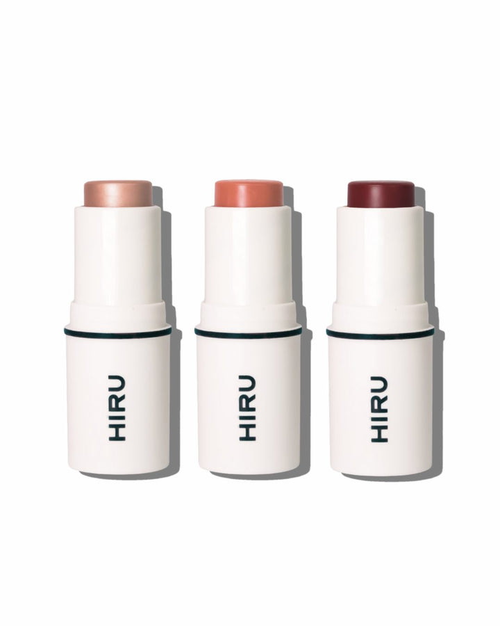 Three HIRU makeup sticks with different shades on a white background